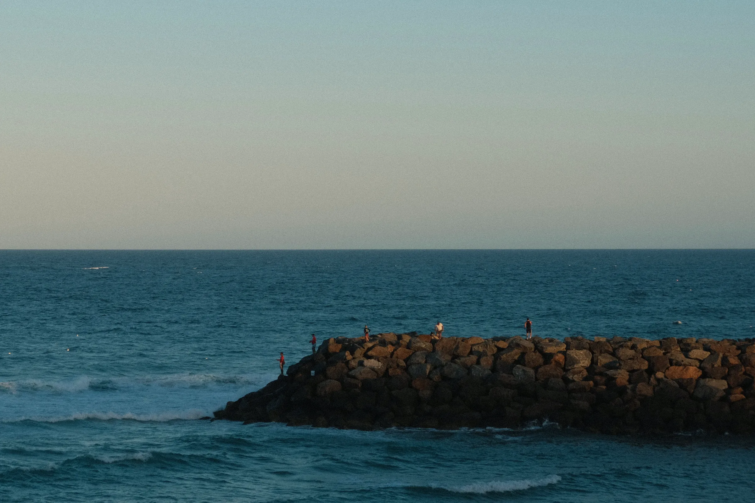 people fishing on rocks
